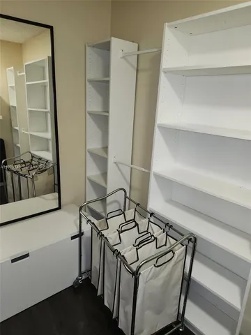 a view of walk in closet with clothes and shoes