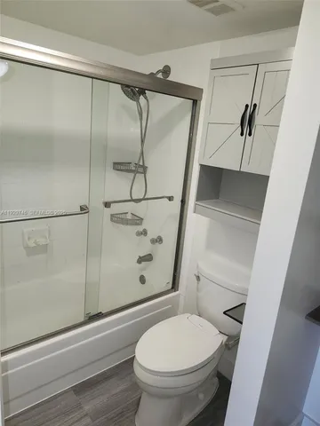 a bathroom with a toilet and a shower