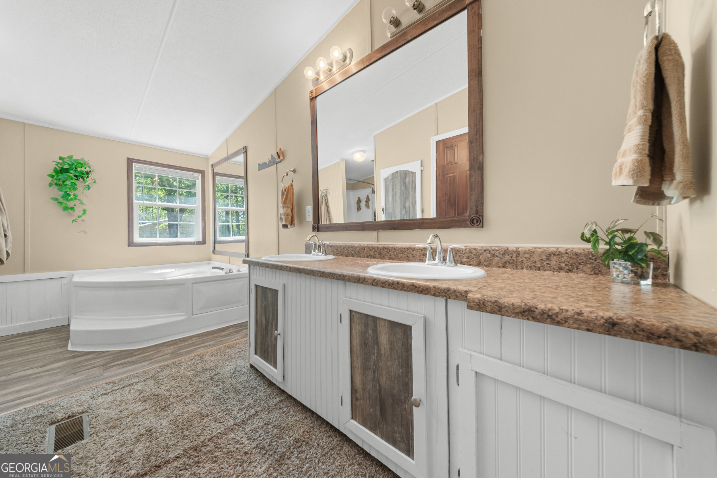 3347 Dickey Road Millen, GA 30442 - Photo 22 of 31 a bathroom with a granite countertop sink and a bathtub