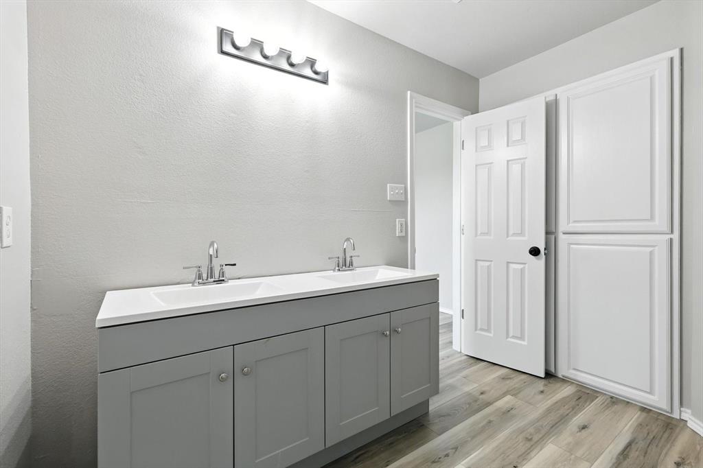 621 Torero Trail Oak Point, TX 75068 - Photo 23 of 34 a bathroom with a double vanity sink and mirror