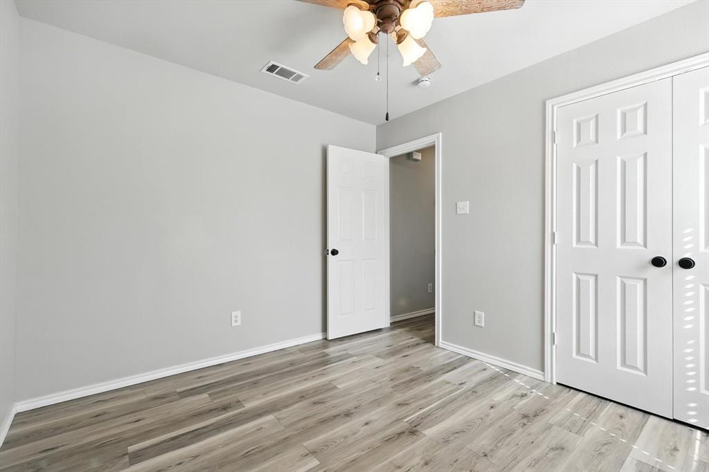 621 Torero Trail Oak Point, TX 75068 - Photo 28 of 34 an empty room with wooden floor chandelier fan and closet area