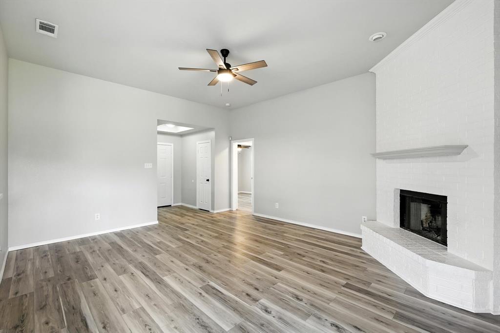 621 Torero Trail Oak Point, TX 75068 - Photo 10 of 34 a view of an empty room with wooden floor fireplace and a window