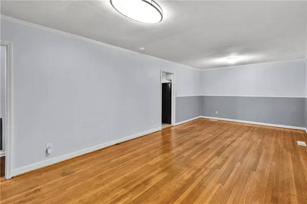 a view of empty room with wooden floor