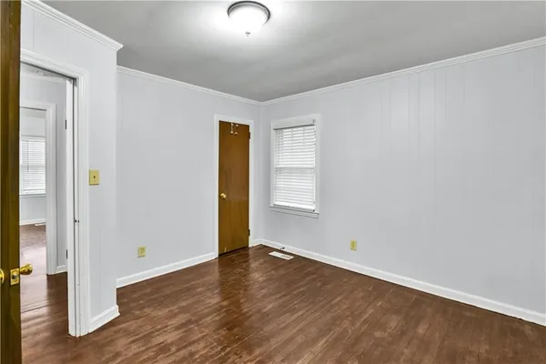 a view of an empty room with window and a bathroom