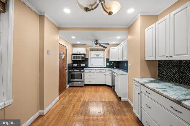 a kitchen with stainless steel appliances granite countertop a refrigerator and a stove top oven
