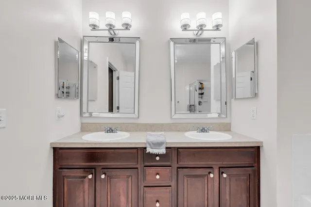 a bathroom with double sink and two mirror