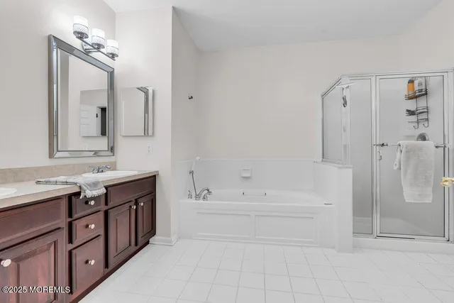 a bathroom with a tub sink and mirror