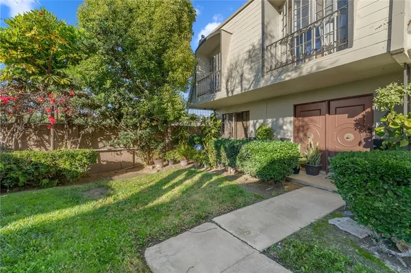 a view of a house with a yard and potted plants