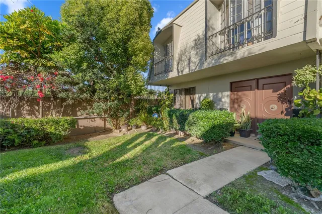 a view of a house with a yard and potted plants