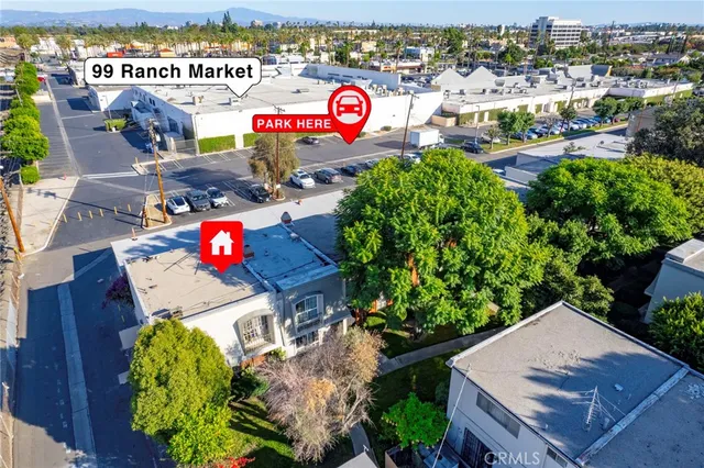 an aerial view of a red and white house with a garden and signage