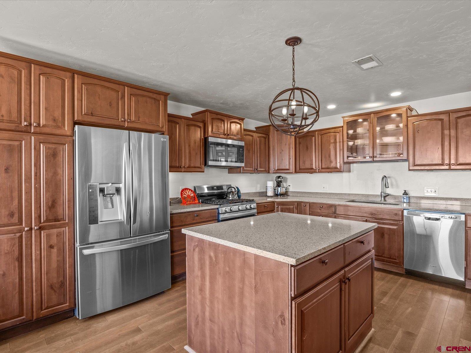 16222 6830th Road Montrose, CO 81401 - Photo 11 of 34 a kitchen with stainless steel appliances granite countertop a refrigerator a sink dishwasher a oven and a dining table with wooden floor