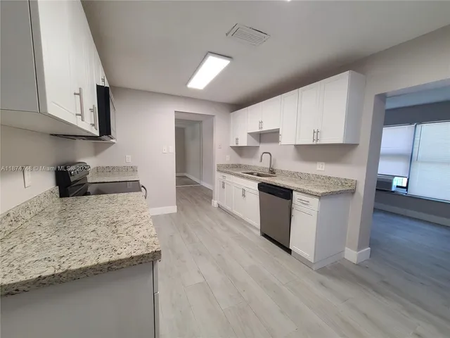 a kitchen with stainless steel appliances granite countertop a stove oven and a white cabinets