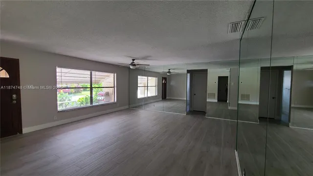 an empty room with wooden floor and windows
