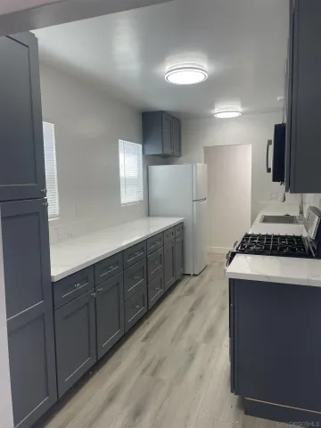 a kitchen with stainless steel appliances granite countertop a stove a sink and a refrigerator