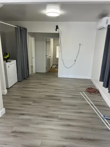 a view of a room with wooden floor and white walls