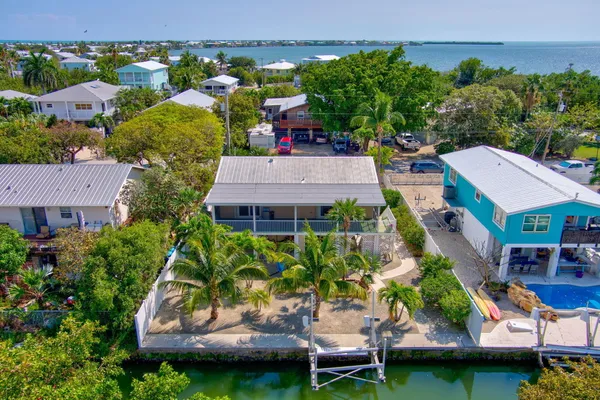 an aerial view of a house with a garden and lake view