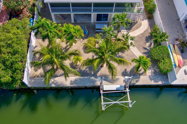 an aerial view of a house with swimming pool and outdoor seating