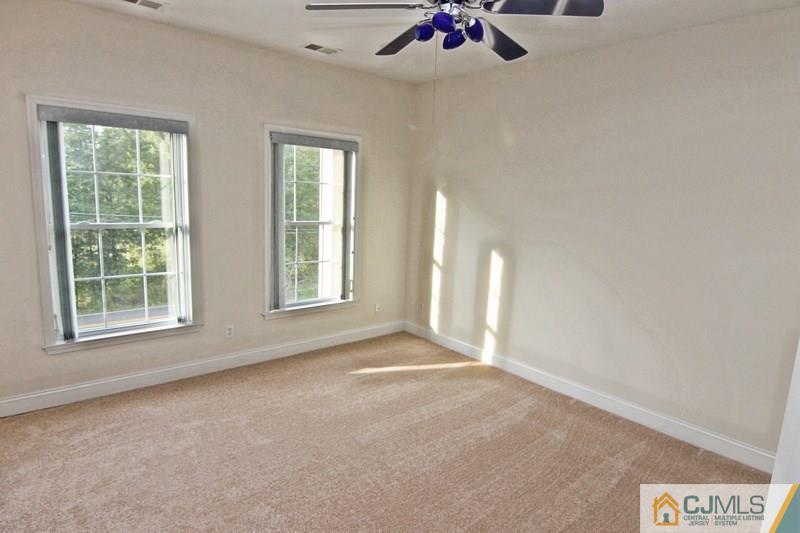 238 Fresh Ponds Road Monroe Township, NJ 08831 - Photo 13 of 17 an empty room with a window and a ceiling fan