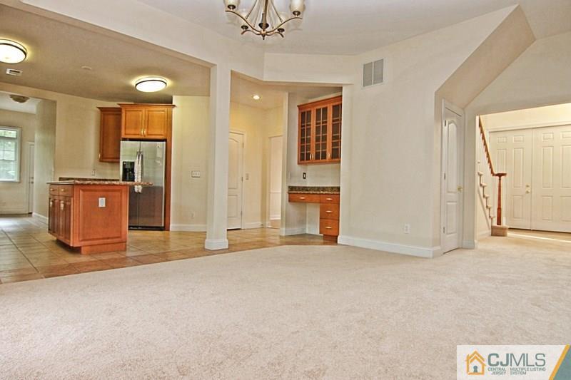 238 Fresh Ponds Road Monroe Township, NJ 08831 - Photo 9 of 17 an empty room with kitchen view and wooden floor