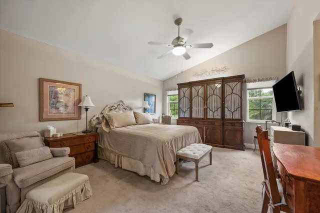 a spacious bedroom with a bed a couch and a flat screen tv