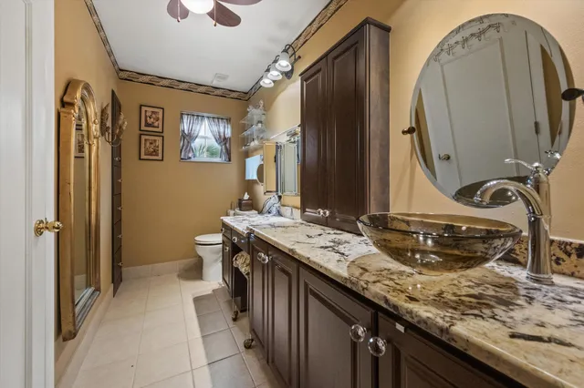 a bathroom with a granite countertop double vanity sink and a mirror
