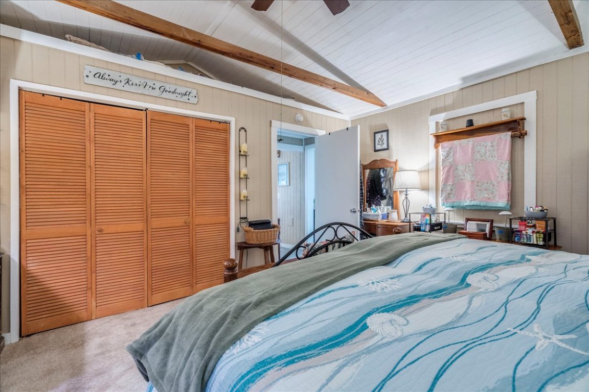 2411 Rohde Road Kyle, TX 78640 - Photo 21 of 40 Carpeted bedroom featuring a closet, ceiling fan, and wood walls
