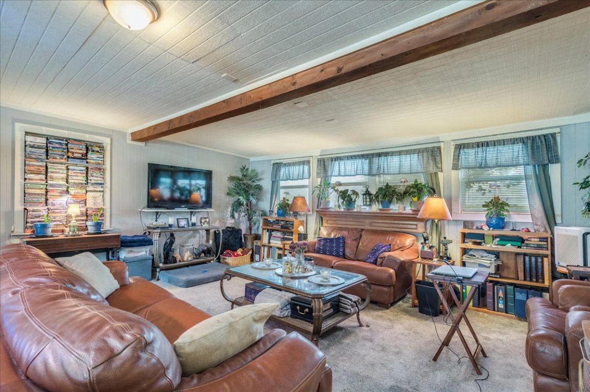 2411 Rohde Road Kyle, TX 78640 - Photo 8 of 40 Living area with carpet flooring, beam ceiling, and plenty of natural light