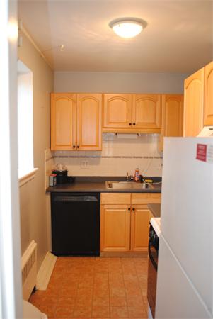 79 Sutherland Road, Unit 1 Boston, MA 02135 - Photo 4 of 10 a kitchen with stainless steel appliances granite countertop a stove a sink and a refrigerator