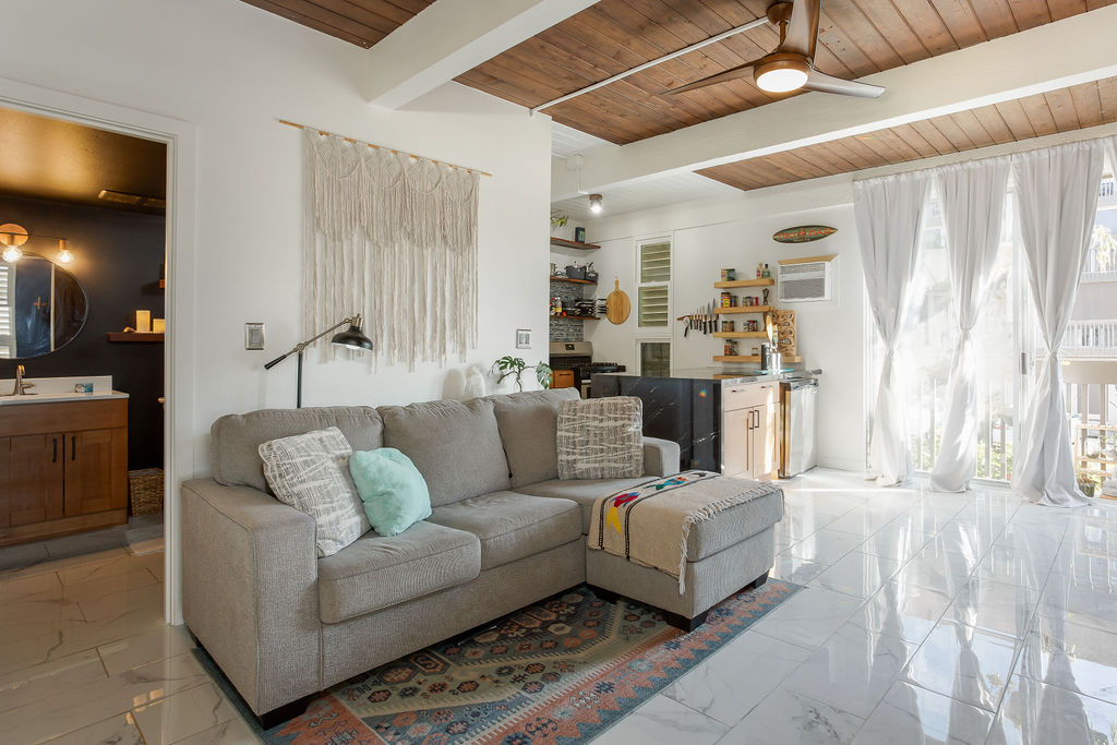 75-5873 Walua Road, Unit 212 Kailua-Kona, HI 96740 - Photo 1 of 17 a living room with furniture and a flat screen tv