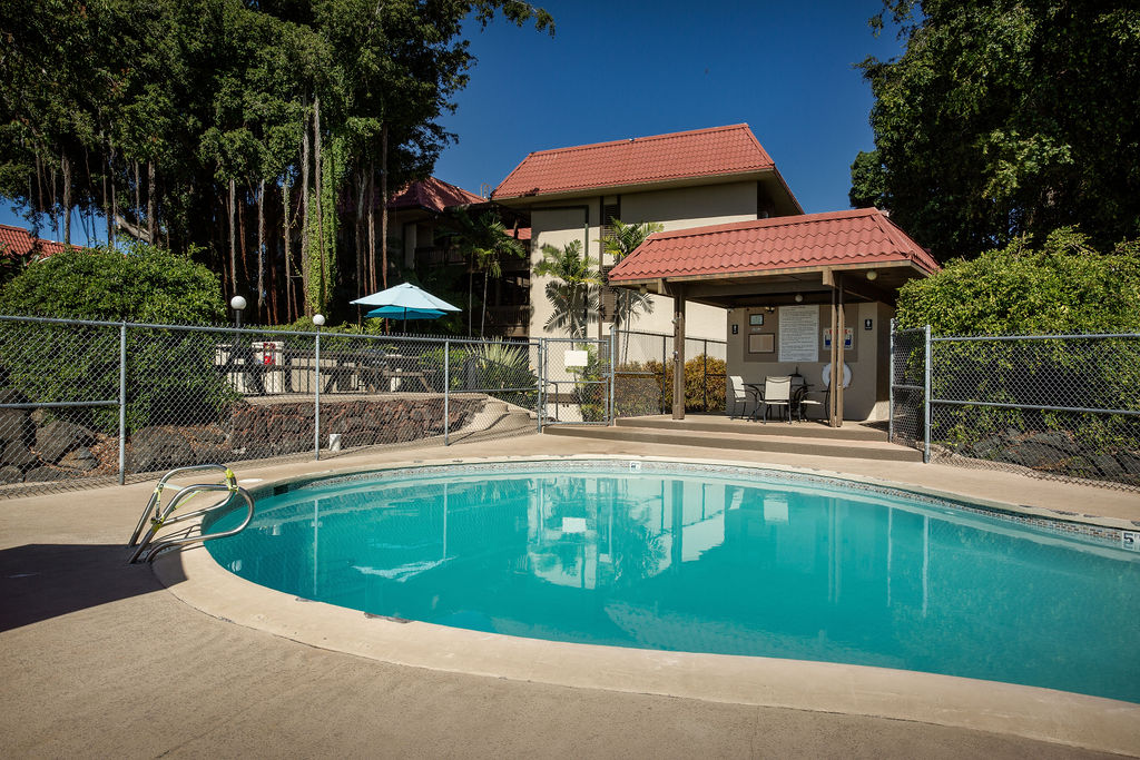 75-5873 Walua Road, Unit 212 Kailua-Kona, HI 96740 - Photo 16 of 17 a view of swimming pool with lawn chairs under an umbrella