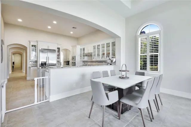 a dining room with stainless steel appliances granite countertop a dining table chairs and granite counter tops
