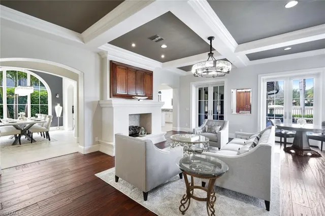 a living room with furniture a fireplace and a chandelier