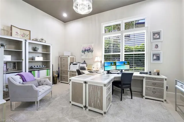 a view of a workspace with furniture and a window