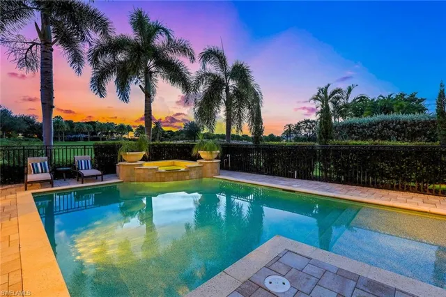a view of a swimming pool with a table and chair a fire pit