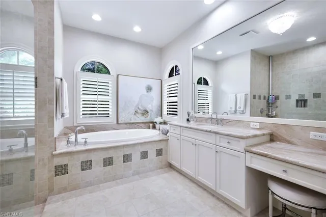 a spacious bathroom with a granite countertop double vanity and a large mirror