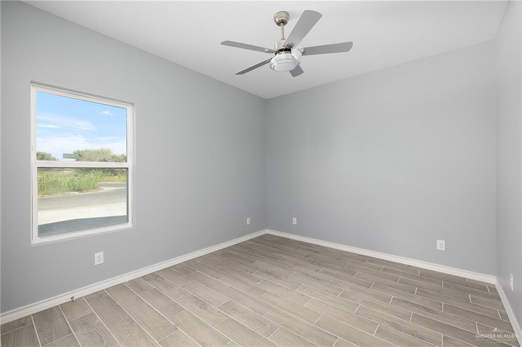 2602 Clearview Street Weslaco, TX 78596 - Photo 7 of 15 an empty room with a window and a fan