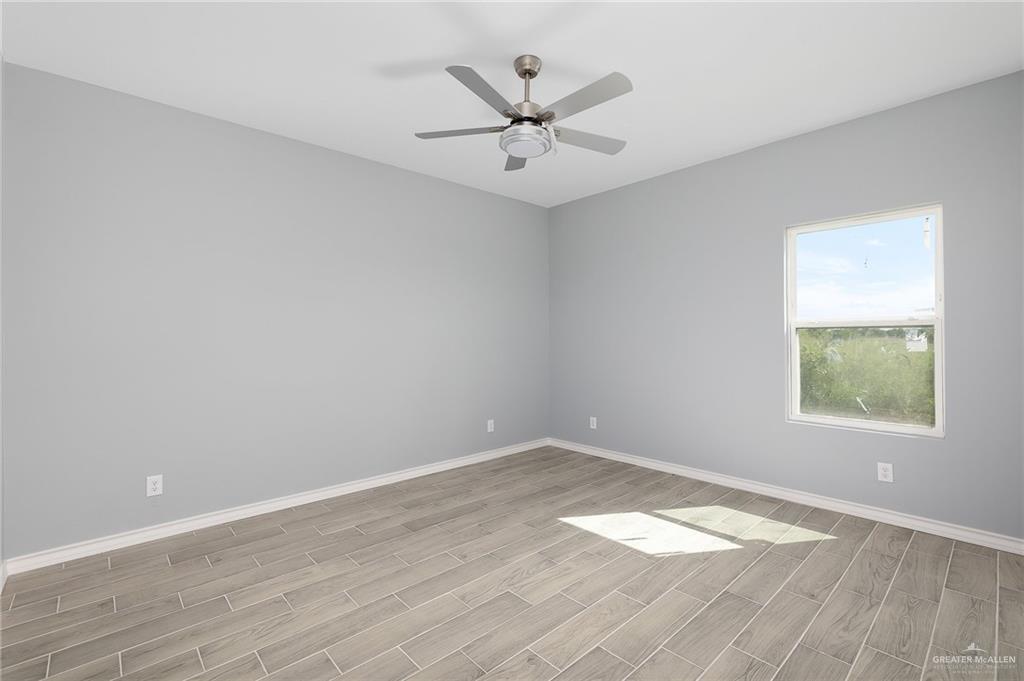 2602 Clearview Street Weslaco, TX 78596 - Photo 8 of 15 an empty room with wooden floor and windows