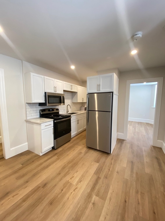 a kitchen with wooden floors and white appliances