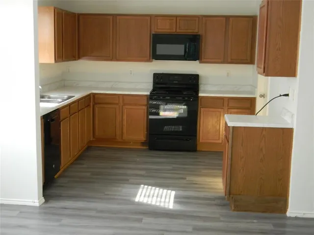 a kitchen with granite countertop a stove top oven and cabinets