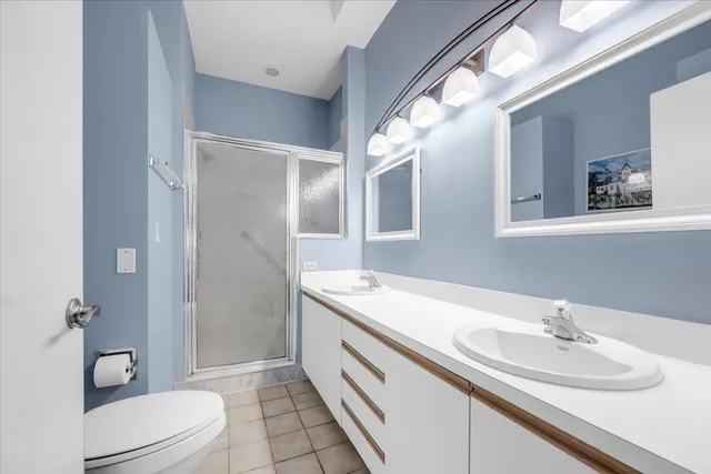 a bathroom with a double vanity sink toilet and shower