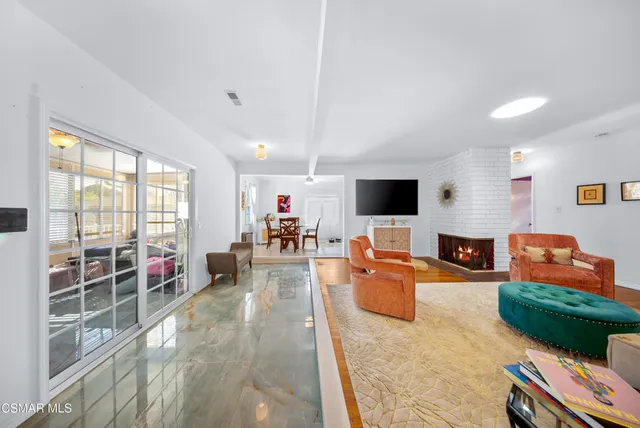 a living room with furniture a flat screen tv and a large window