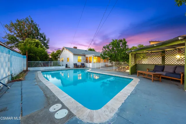 a view of a chairs and table in backyard of the house