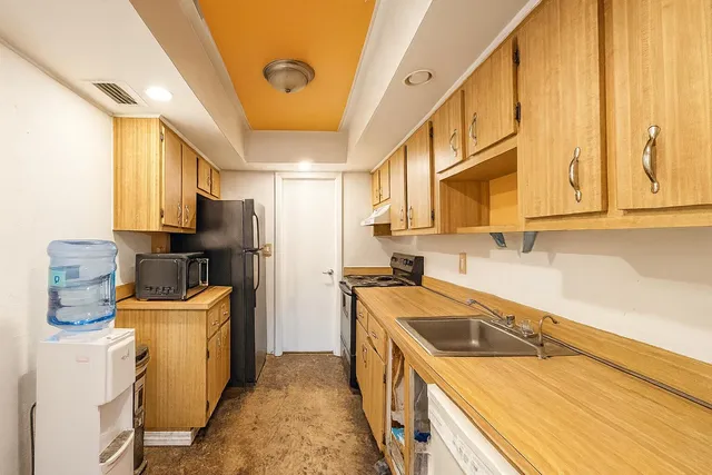 a kitchen with stainless steel appliances granite countertop a refrigerator a stove and a sink