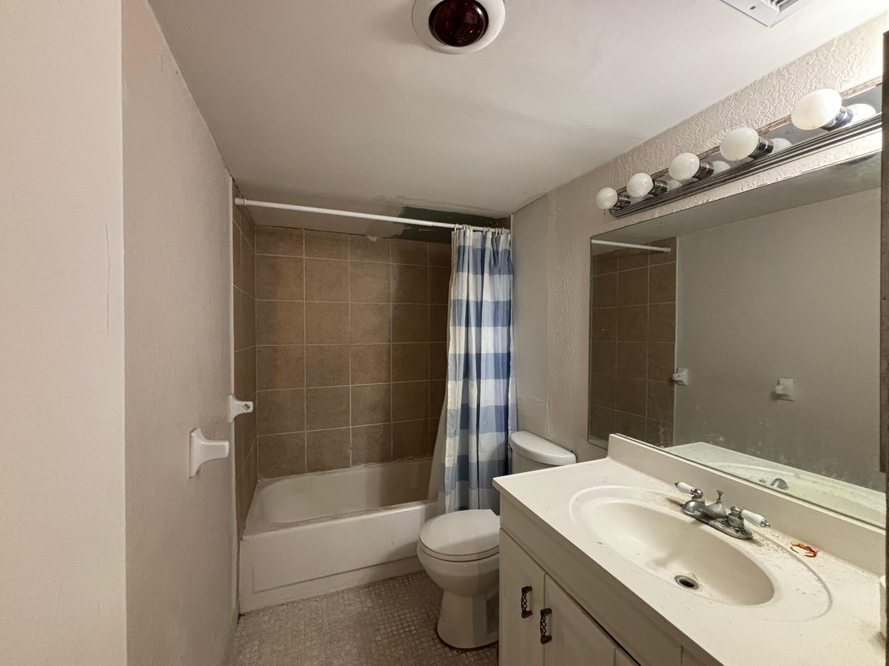 4174 Inverrary Drive, Unit 102 Lauderhill, FL 33319 - Photo 8 of 10 a bathroom with a bathtub shower sink vanity mirror and toilet