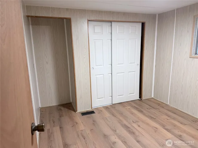 a view of a closet area with wooden floor