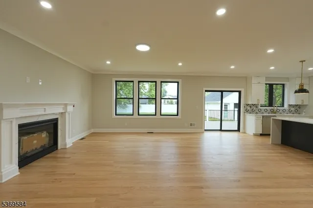 a view of an empty room with a fireplace and a window