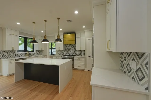 a large kitchen with kitchen island a sink stainless steel appliances and cabinets