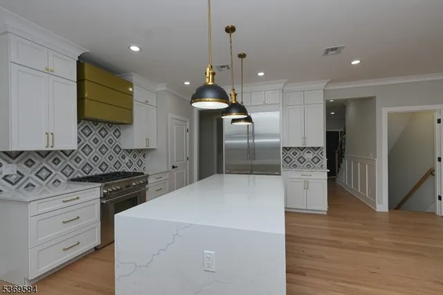 a kitchen with stainless steel appliances granite countertop a sink a stove and a refrigerator