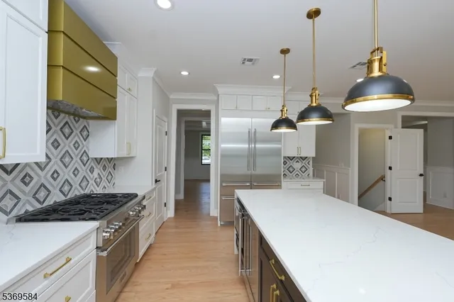 a kitchen with stainless steel appliances granite countertop a sink a stove and a refrigerator