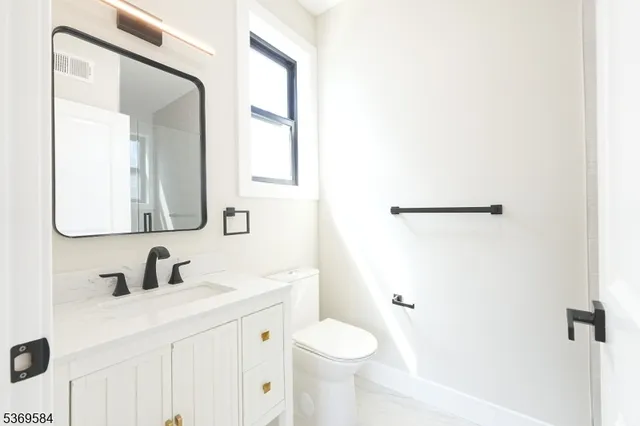 a bathroom with a sink toilet and mirror